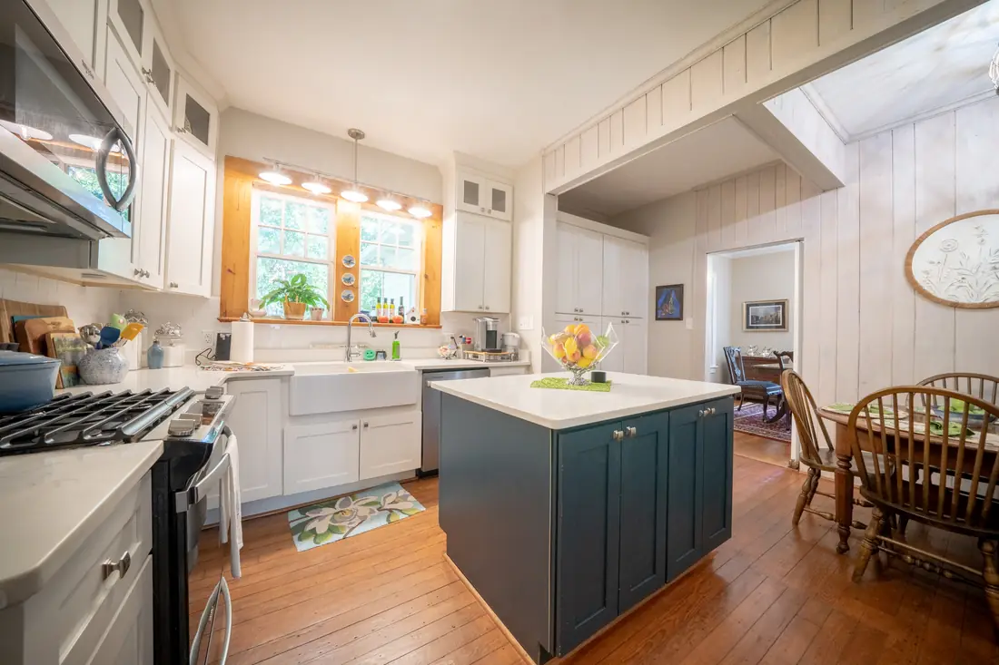 Remodeled kitchen with navy island and white cabinetry